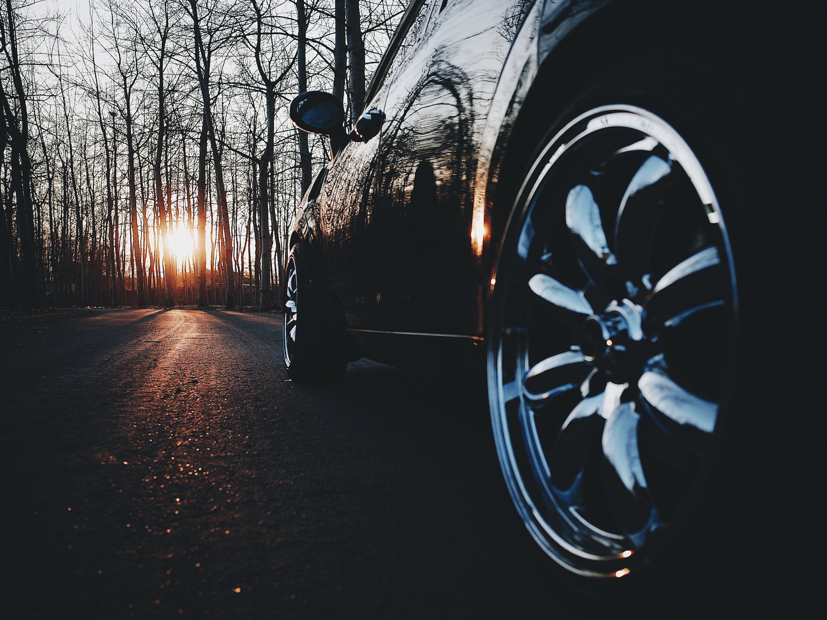 Glossy black paint and a chrome wheel catching a low sun